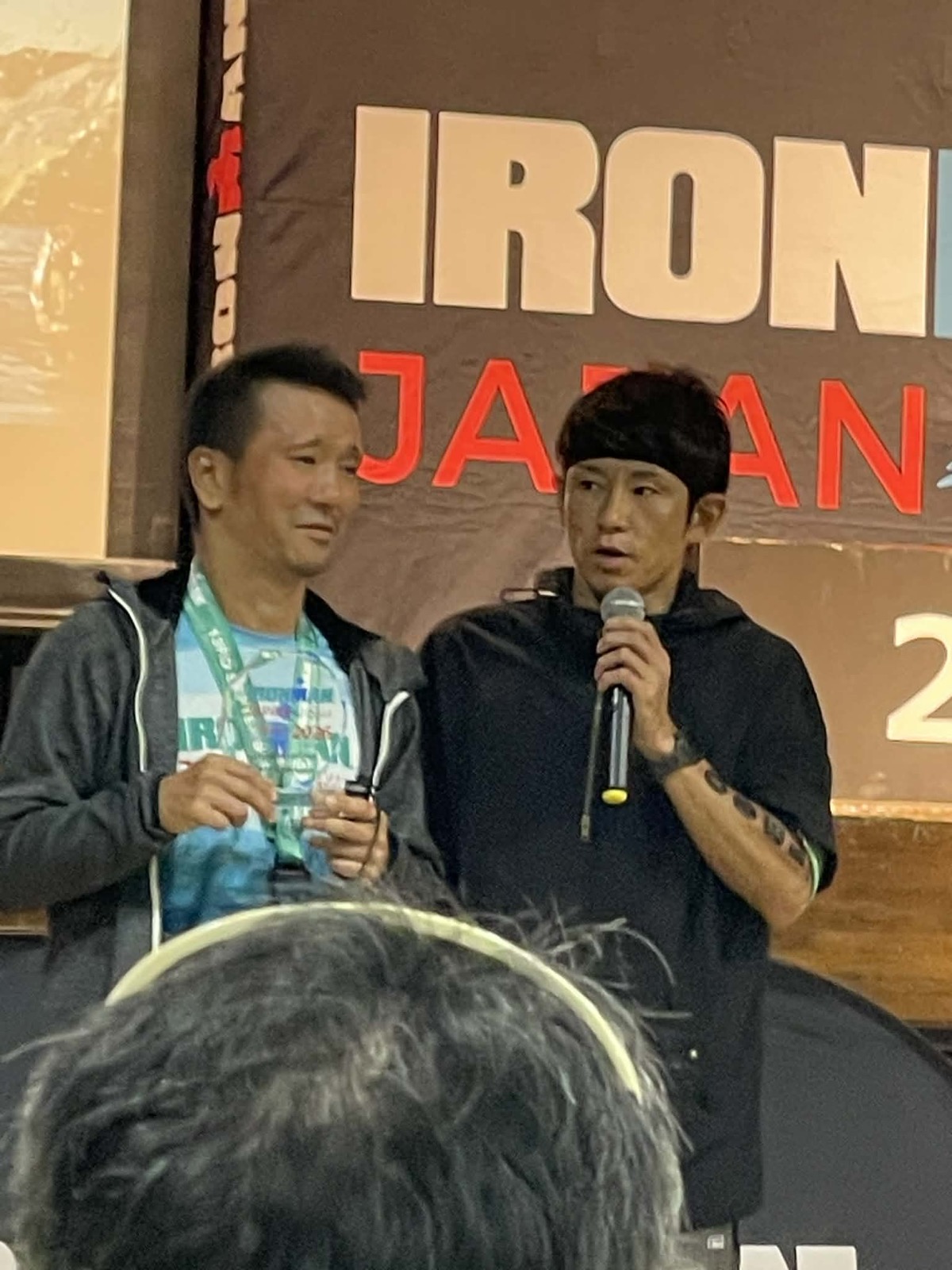 IRONMAN JAPAN 2026の表彰ステージでインタビューを受ける中澤隆